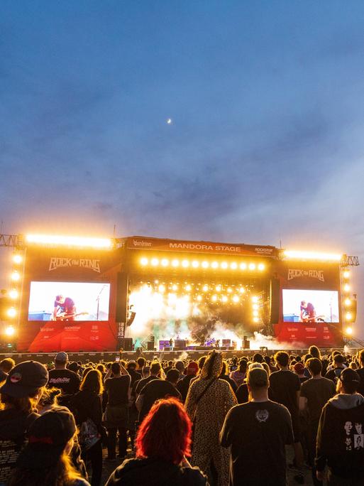Das Publikum steht vor der hell erleuchteten Konzertbühne von "Rock am Ring".