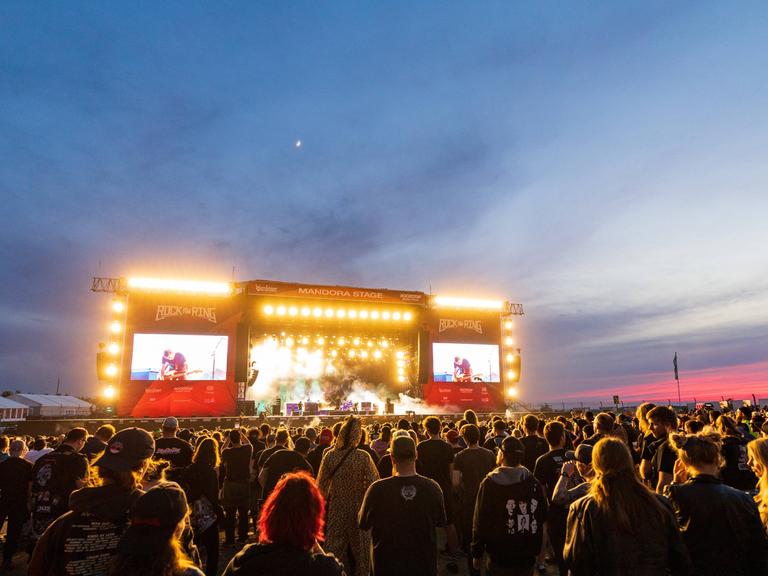 Das Publikum steht vor der hell erleuchteten Konzertbühne von "Rock am Ring".