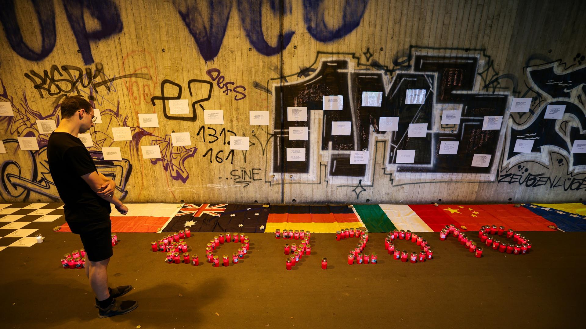 In Duisburg steht ein Mann im Tunnel in der Nähe des Unglücksortes vor Kerzen, die das Datum 24.07.2010 zeigen. Zahlreiche Menschen haben mit einer Nacht der 1.000 Lichter an die Opfer der Loveparade-Katastrophe vor 15 Jahren erinnert. 