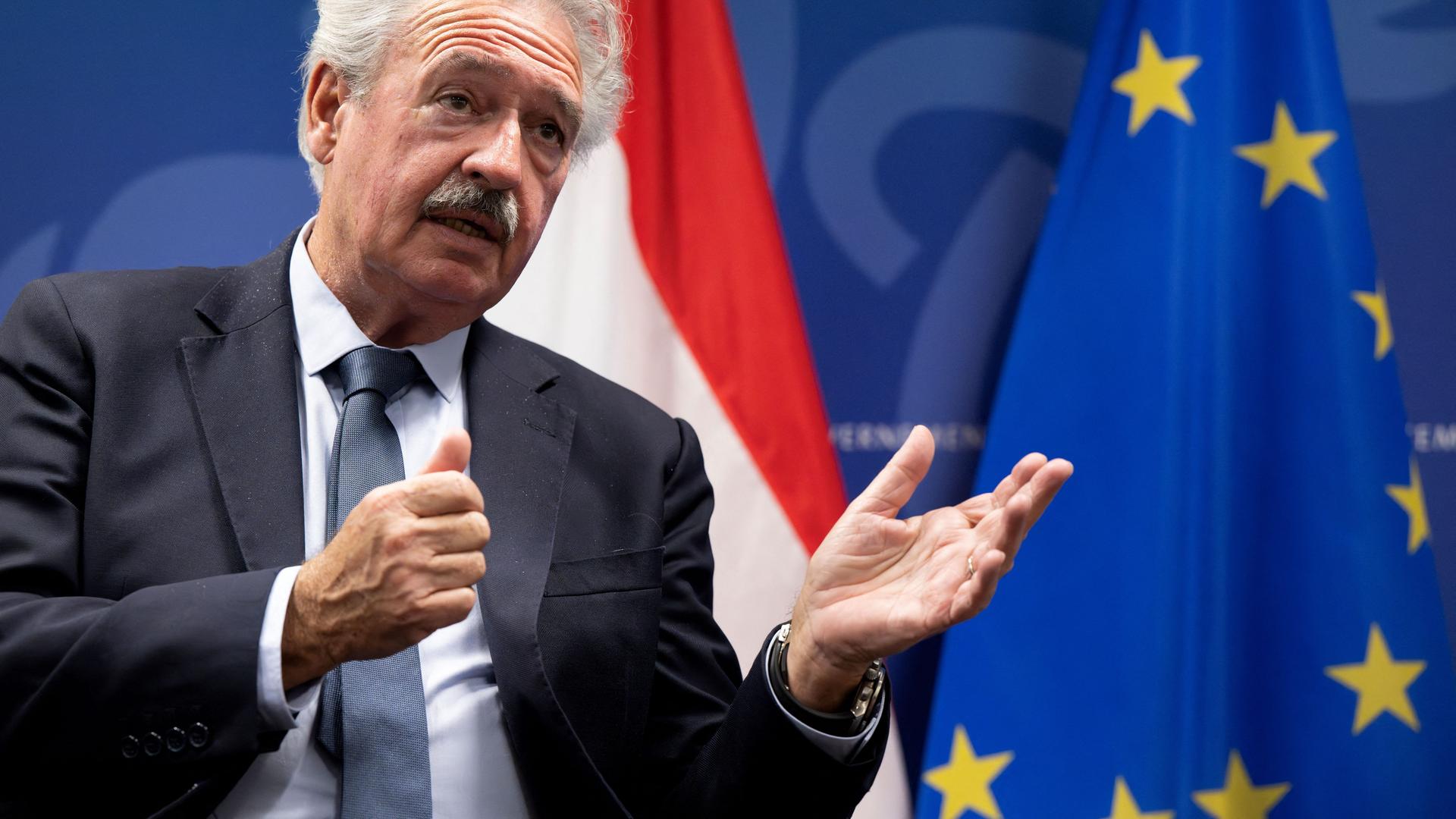 Das Foto zeigt den früheren luxemburgischer Außenminister Jean Asselborn. Er gibt ein Interview und hält seine Hände nach vorne.