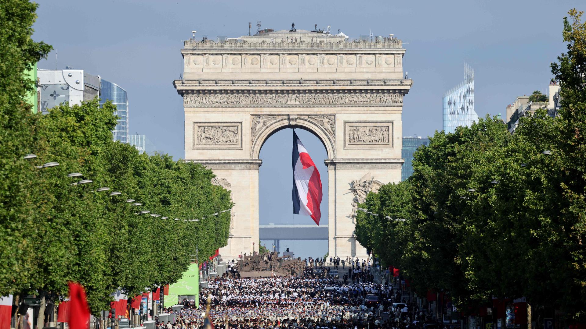 Teilnehmer warten auf den Beginn der jährlichen Militärparade zum Nationalfeiertag auf den Champs-Élysées.