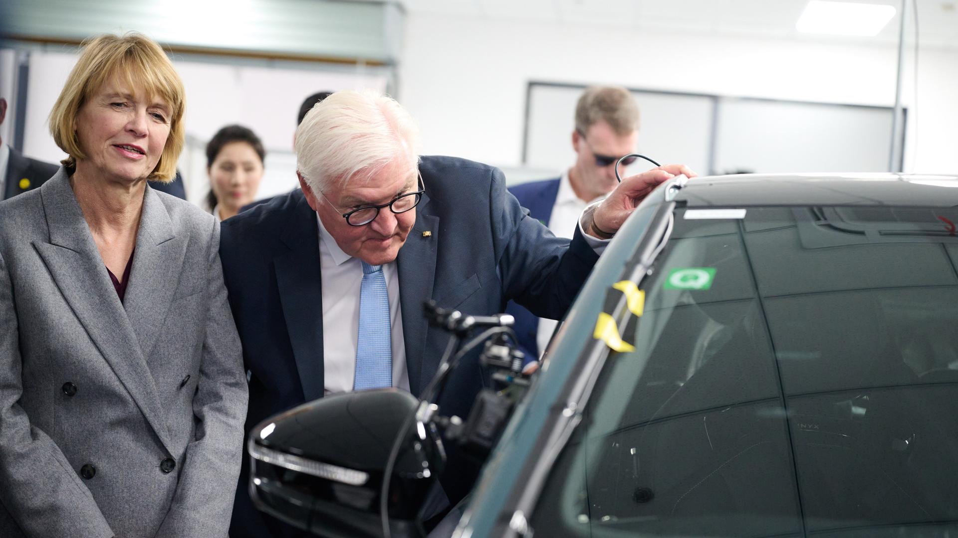 Bundespräsident Frank-Walter Steinmeier und seine Frau Elke Büdenbender besuchen einen Standort der Volkswagen Group China und schauen sich einen Volkswagen mit einem Roboterarm im Inneren an. Bundespräsident Frank-Walter Steinmeier und seine Frau Elke Büdenbender besuchen einen Standort der Volkswagen Group China und schauen sich einen Volkswagen mit einem Roboterarm im Inneren an.
