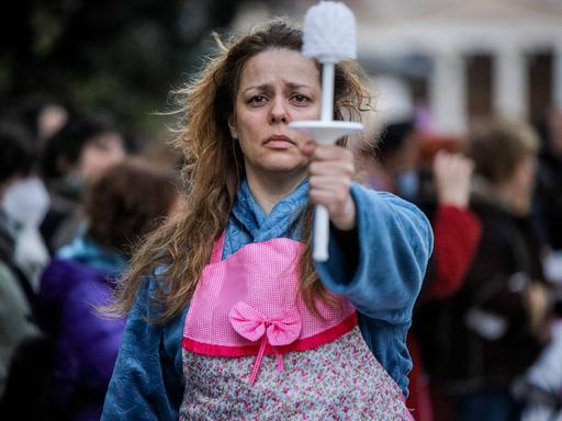 Eine Frau hält bei einer Demonstration für Frauenrechte eine Klobürste in der Hand.