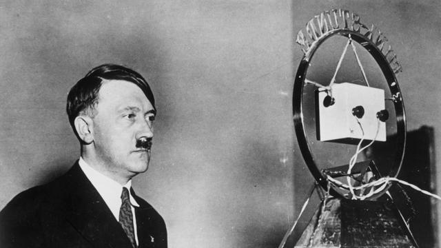 Die erste Rundfunkrede von Reichkanzler Adolf Hitler am 1. Februar 1933: Hitler ist vor einem großen, altmodischen Mikrofon zu sehen. Die erste Rundfunkrede von Reichkanzler Adolf Hitler am 1. Februar 1933: Hitler ist vor einem großen, altmodischen Mikrofon zu sehen.