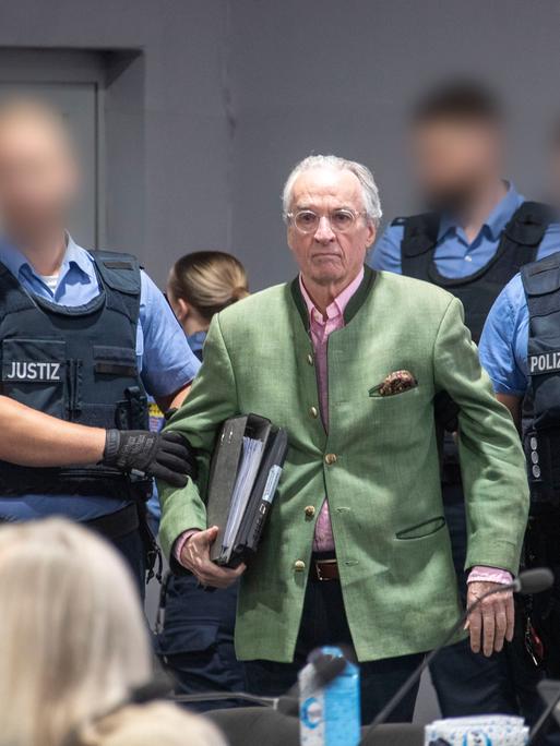 Heinrich XIII. Prinz Reuß (M), Hauptangeklagter im Prozess gegen eine mutmaßliche "Reichsbürger-Gruppe", wird von Justizbeamten in den Gerichtssaal geführt.