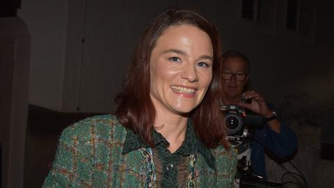 Die Schauspielerin Valérie Pachner bei der Premierenfeier von "Jedermann" bei den Salzburger Festspielen. Sie trägt einen grünen Hosenanzug und lacht in die Kamera.