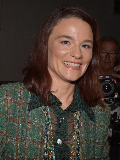 Die Schauspielerin Valérie Pachner bei der Premierenfeier von "Jedermann" bei den Salzburger Festspielen. Sie trägt einen grünen Hosenanzug und lacht in die Kamera.