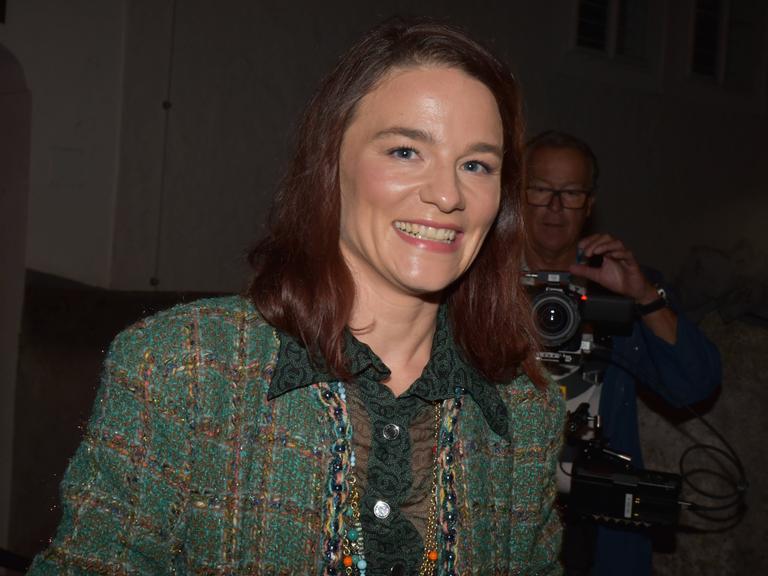 Die Schauspielerin Valérie Pachner bei der Premierenfeier von "Jedermann" bei den Salzburger Festspielen. Sie trägt einen grünen Hosenanzug und lacht in die Kamera.