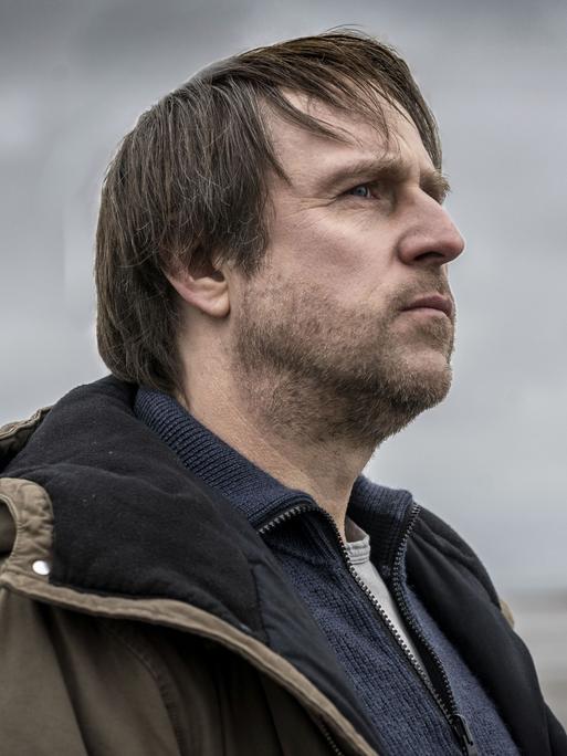 Bjarne Mädel blickt als Kommissar Sörensen an der Nordseeküste in die Weite.