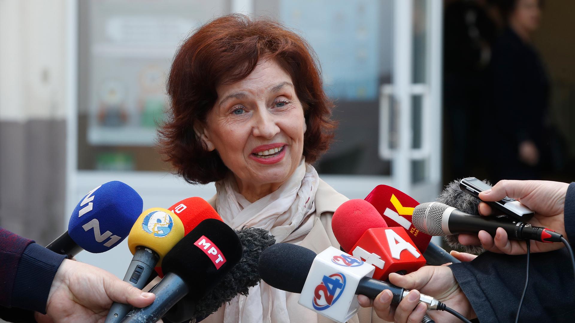 Das Bild zeigt eine siegesgewiss schauende Gordana Siljanovska-Davkova vor zahlreichen Mikrofonen nordmazedonischer Medien.