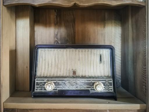Blick auf ein historisches Radio, das in einem altmodischen Regal steht.