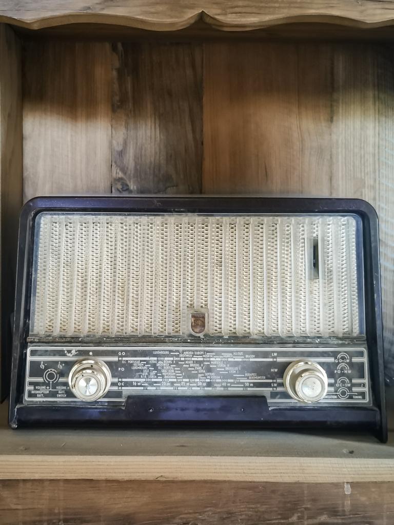 Blick auf ein historisches Radio, das in einem altmodischen Regal steht.
