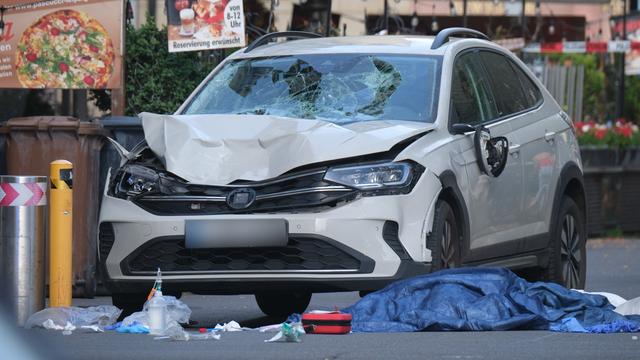 Ein weißer Klein-Wagen mit kaputtem Vorderteil steht in der Leipziger Fußgänger-Zone. Daneben stehen Sanitäter.