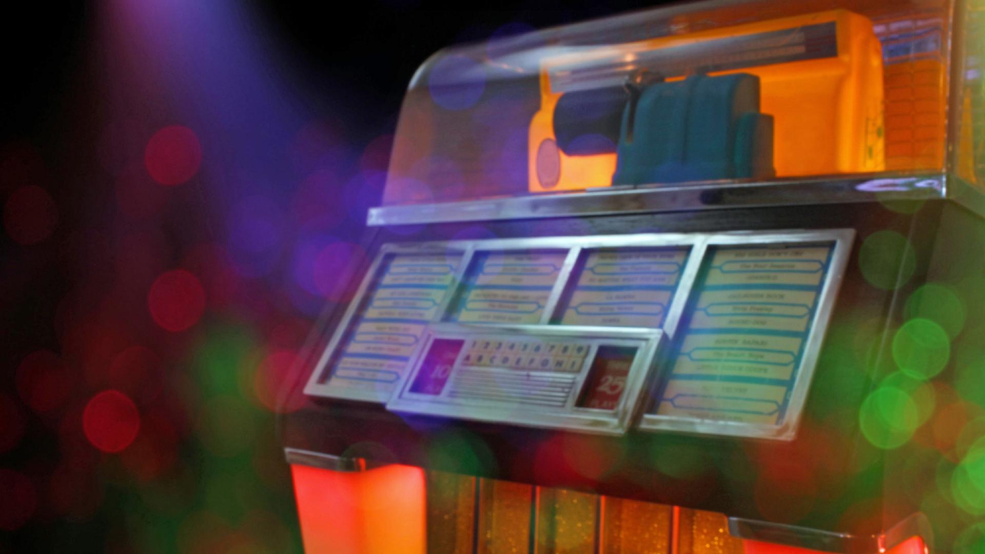 Ihre Glanzzeit hatte die Jukebox in der Mitte des letzten Jahrhunderts. Zu sehen: Eine Jukebox mit unterschiedlichen Farben beleuchtet. 