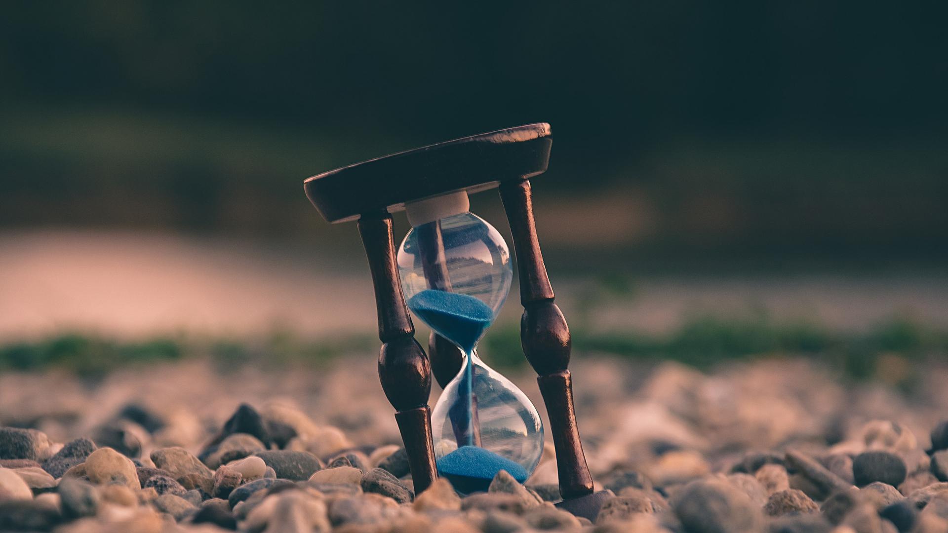 Eine Sanduhr steht auf dem Boden. 