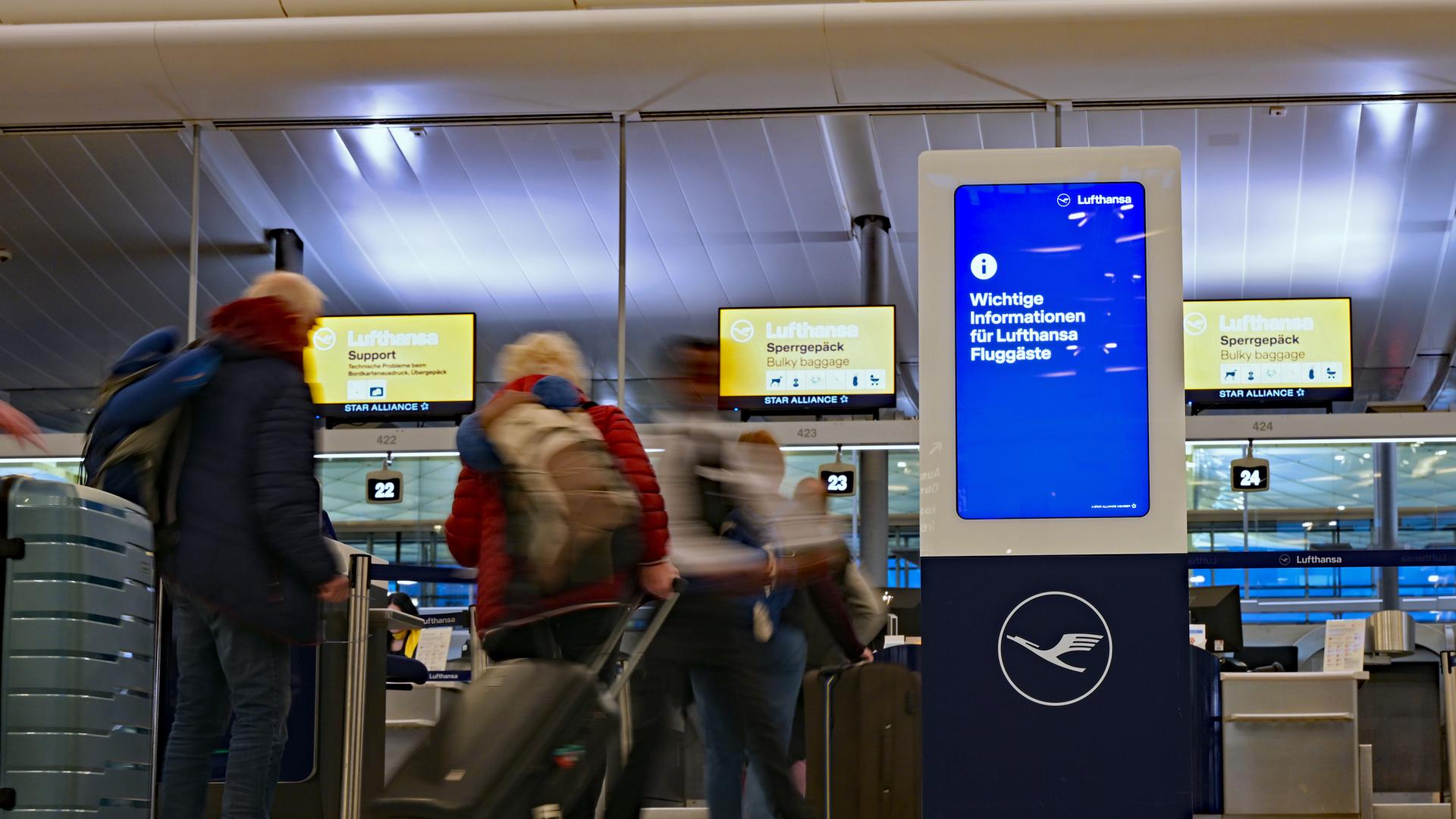 München: Passagiere laufen an Lufthansa-Schaltern vorbei.