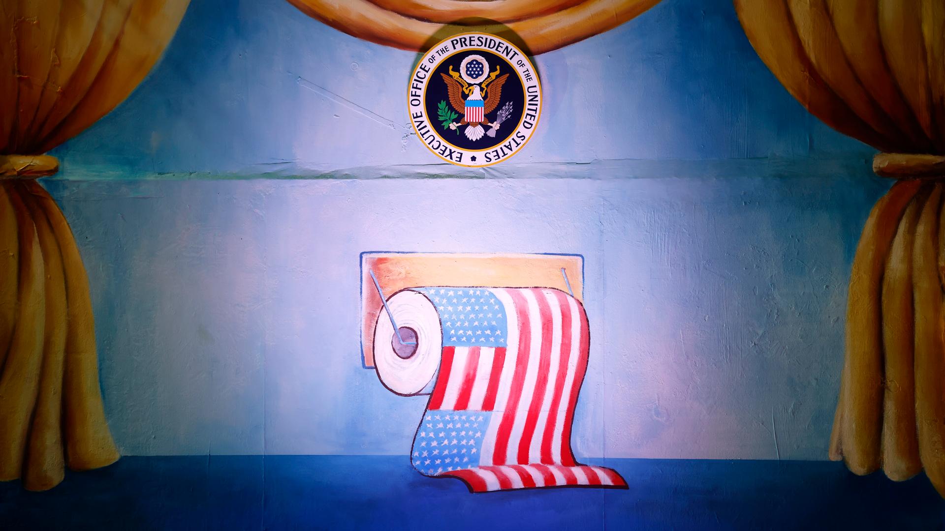 Zu sehen ist eine Klorolle mit der Flagge der Vereinigten Staaten von Amerika beim Richtfest der Persiflage- und Motivwagen zum Kölner Rosenmontagszug 2023 in der Koelnmesse.