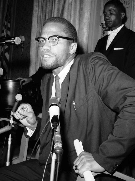 Malcolm X umringt von Mikrofonen bei einer Pressekonferenz im Jahr 1963.