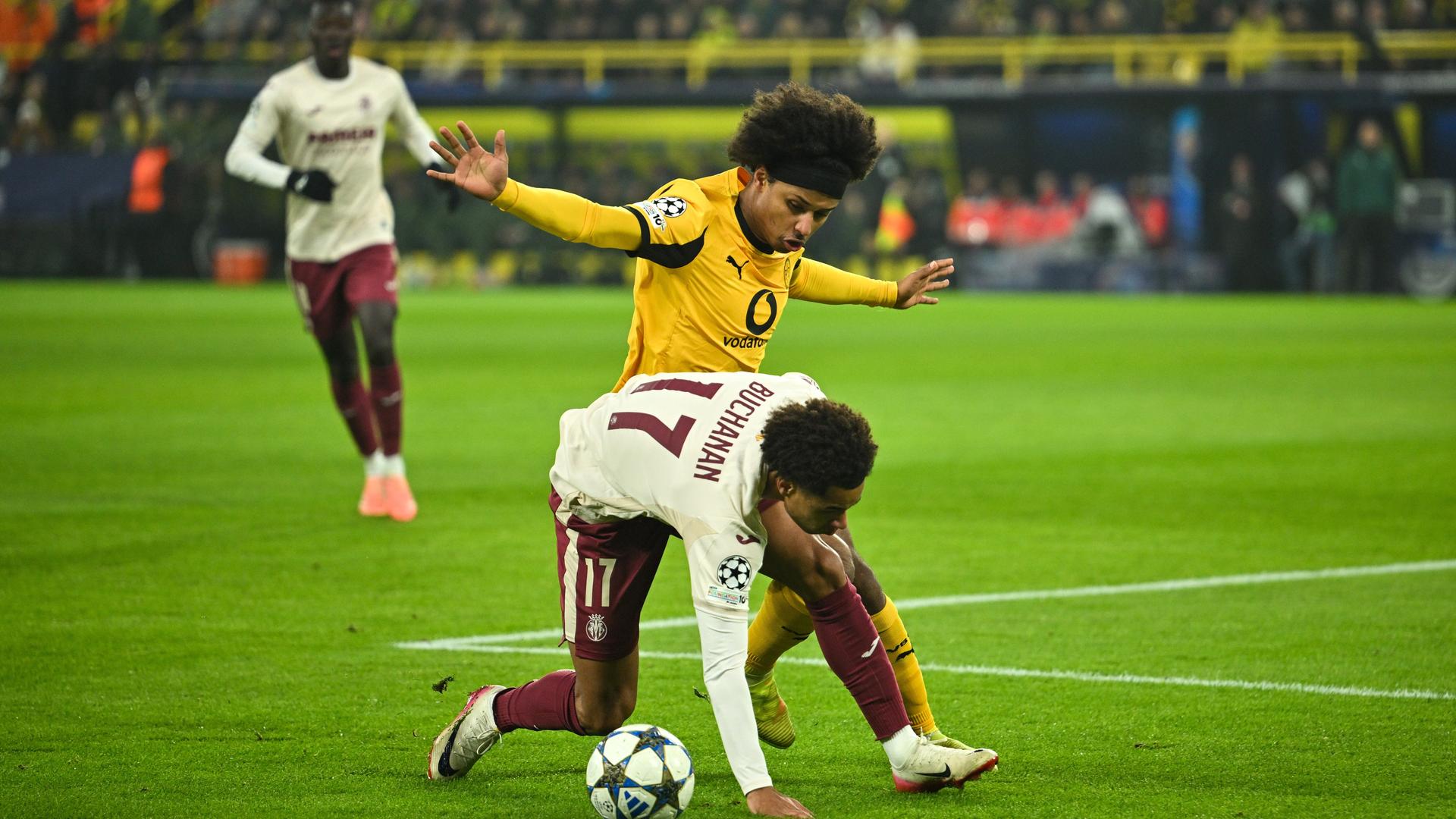 Adeyemi im gelben Trikpt bedrängt Buchanan im weißen Trikot mit ausgebreitetem Armen von der Seite. Buchanan kippt nach vorne und stützt sich mit der linken Hand am Boden ab. Adeyemi im gelben Trikpt bedrängt Buchanan im weißen Trikot mit ausgebreitetem Armen von der Seite. Buchanan kippt nach vorne und stützt sich mit der linken Hand am Boden ab.