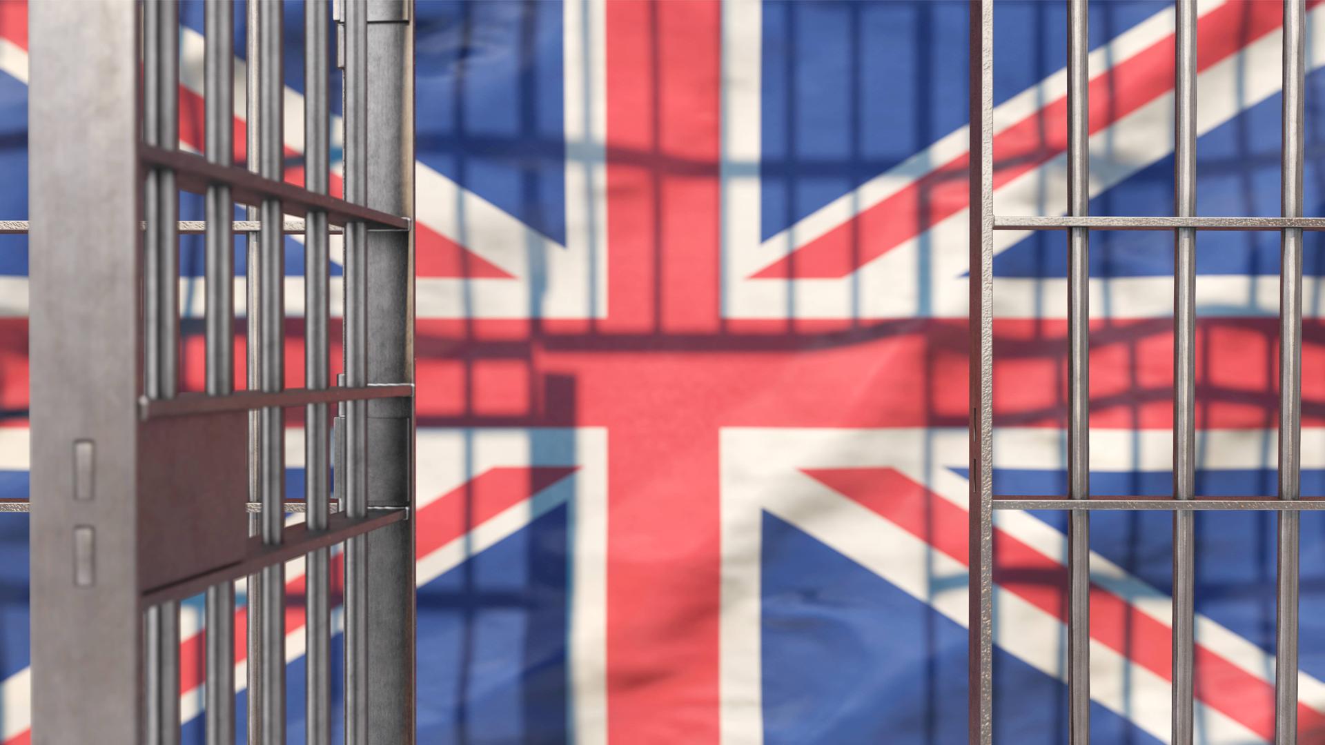 Eine offene Gefängnistür vor der Flagge Großbritanniens.