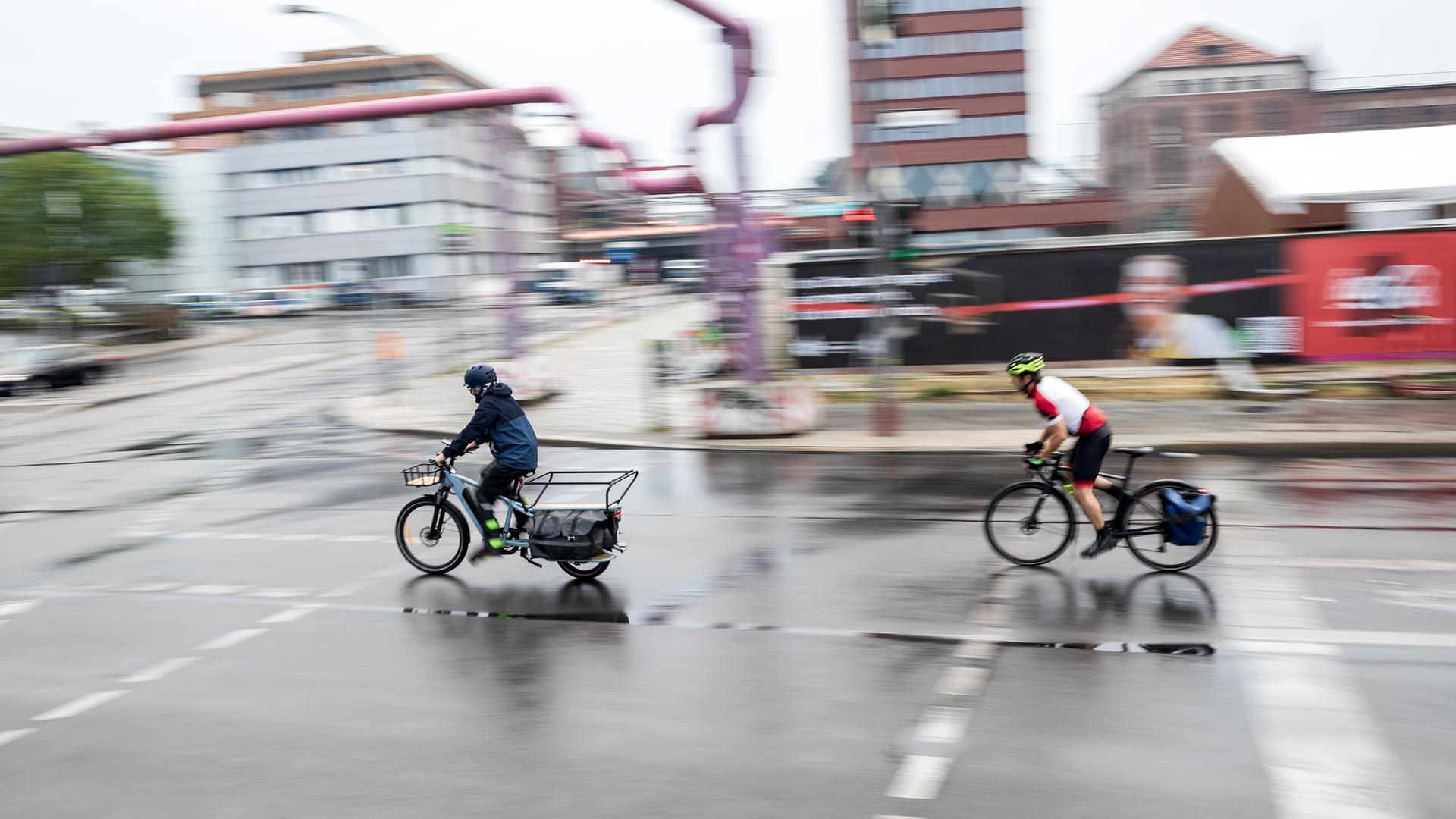 Berlin: Ein Lastenradfahrer und ein Rennradfahrer fahren über eine Kreuzung an einer Hauptverkehrsstraße. Das Bundeskabinett will eine Reform des Straßenverkehrsgesetzes beschließen.