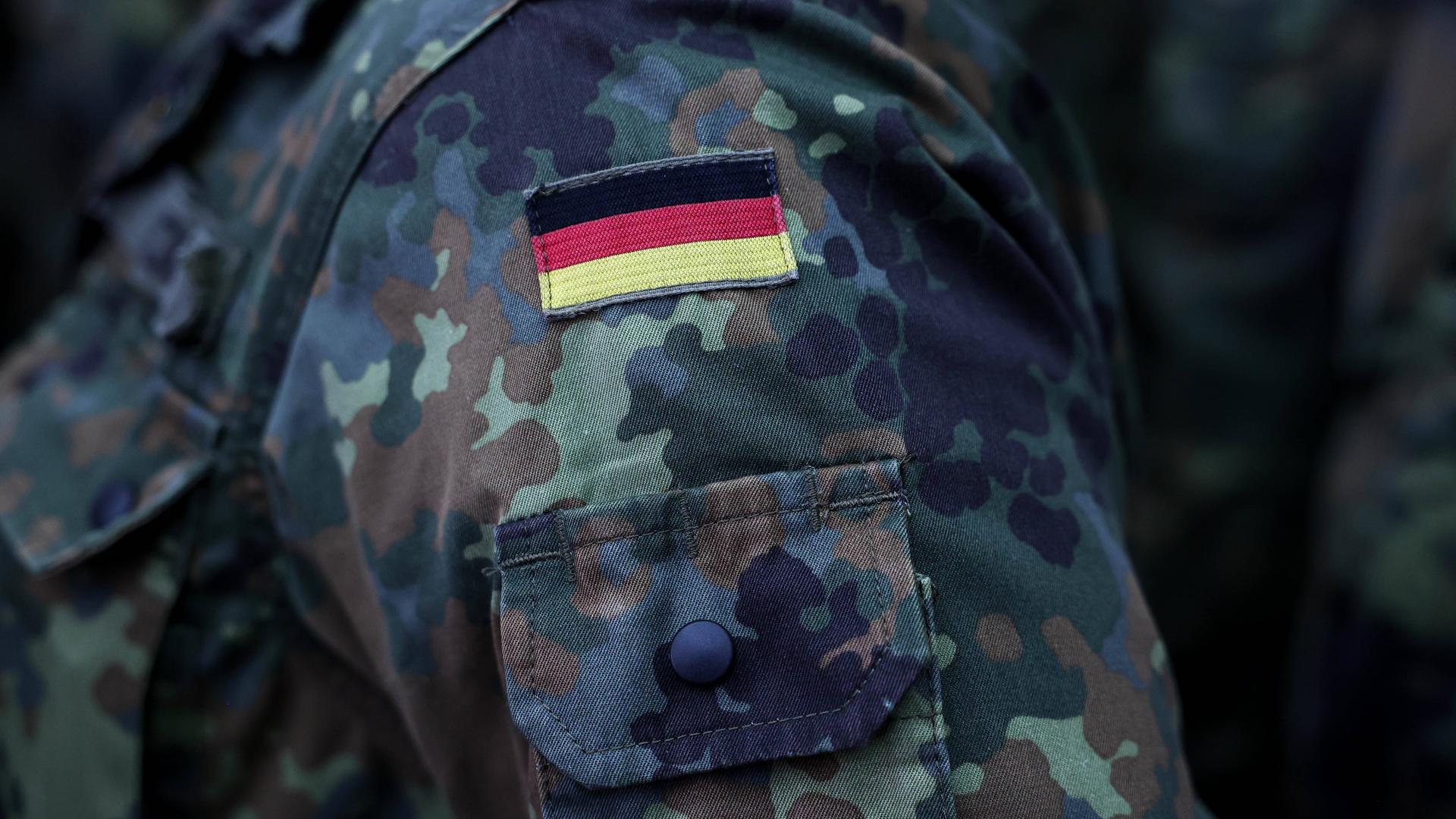 Nahaufnahme der deutschen Flagge auf Bundeswehrkleidung beim Verabschiedungsappell des Taktischen Luftwaffengeschwaders 74 am 26.02.2024 im Fliegerhorst Neuburg in Neuburg an der Donau