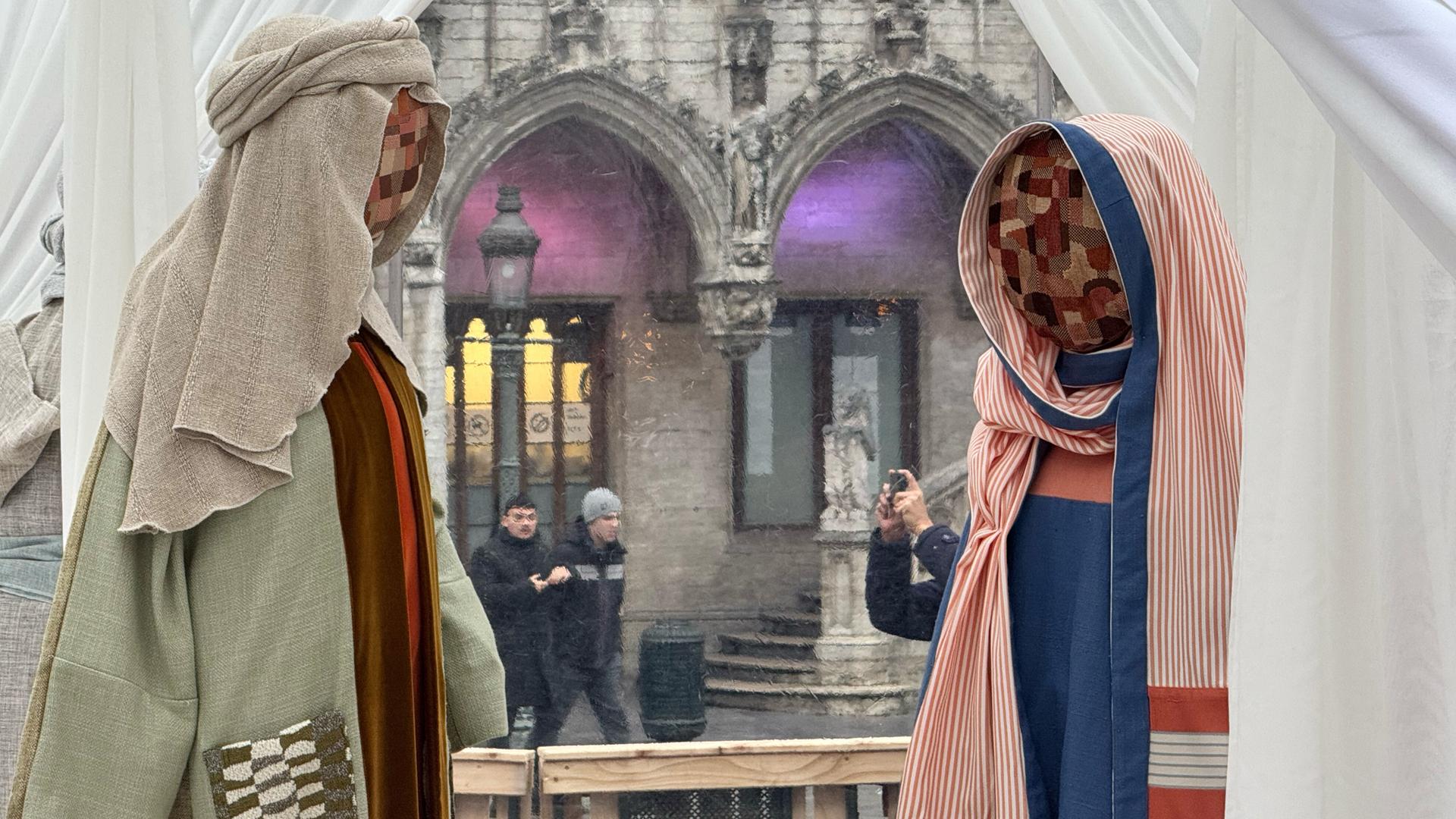 Eine Krippe mit Figuren mit Stoffgesichtern der belgischen Künstlerin Victoria-Maria Geyer wird in einem weißen Zelt in Brüssel ausgestellt.