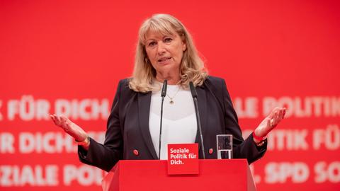 Petra Köpping spricht an einem roten Pult mit der Aufschrift "SPD - Soziale Politik für Dich". Dahinter eine rote Wand mit der gleichen Aufschrift SPD
