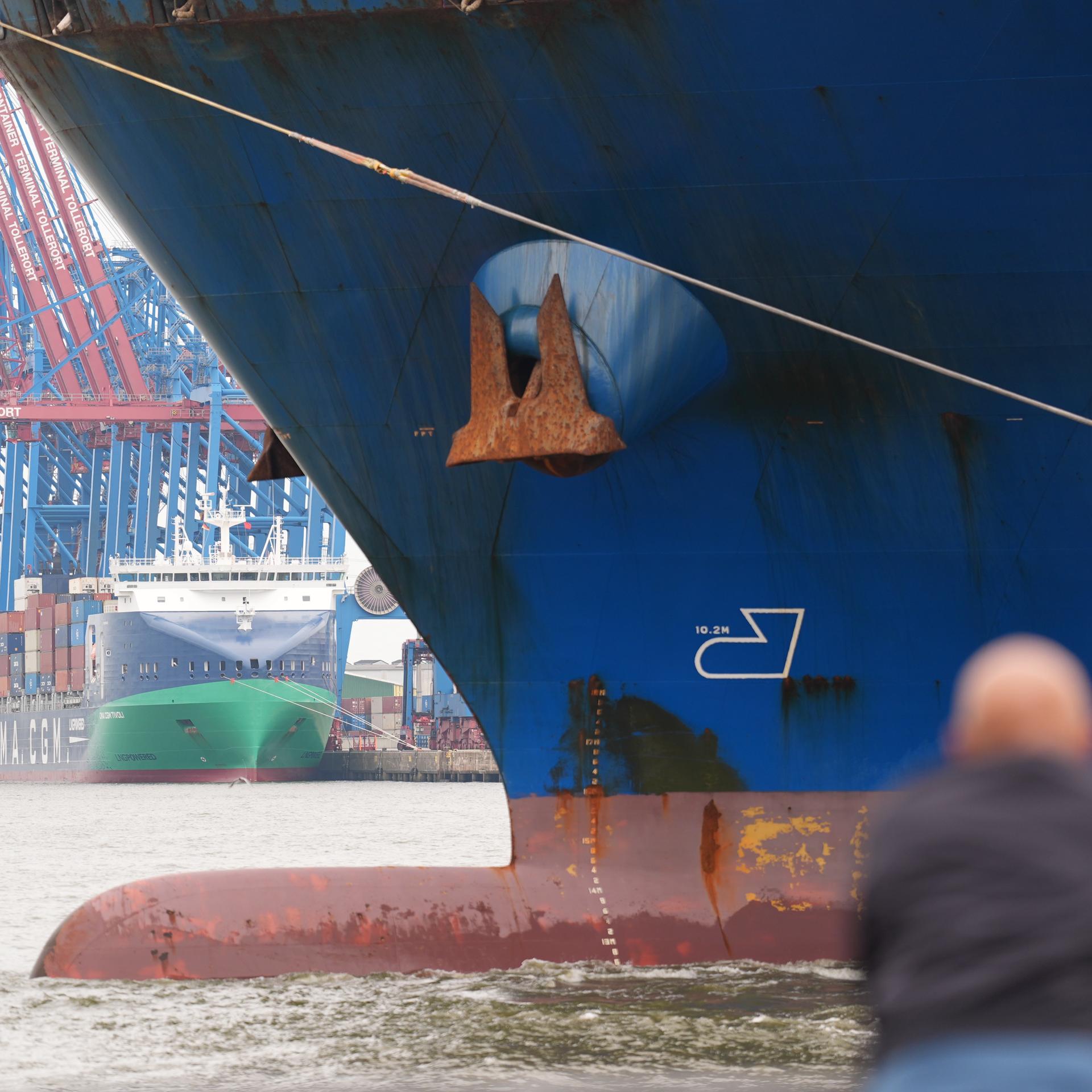 Ein Passant verfolgt das Anlegemanöver des riesigen Containerschiffs "Cosco Shipping Virgo" der Reederei Cosco Shipping, während es im Hamburger Hafen von Schleppern an den Container-Terminal Tollerort gezogen wird.