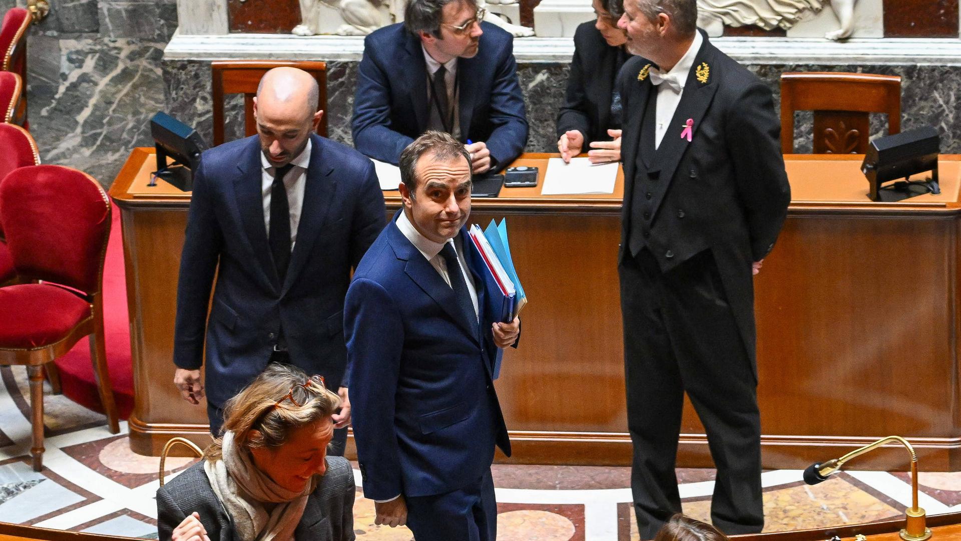 Frankreichs Premier Sébastien Lecornu läuft nach überstandenem Misstrauensvotum lächelnd durch die französische Nationalversammlung.
