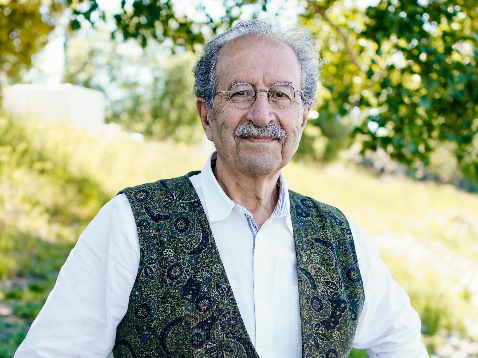 Der Schriftsteller Rafik Schami steht am Rheinufer