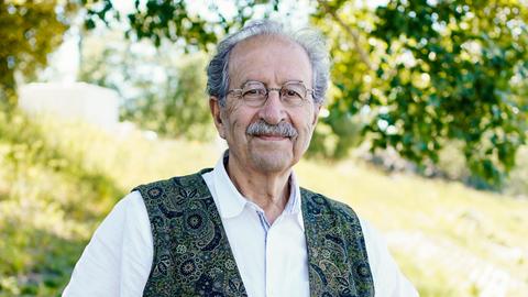 Der Schriftsteller Rafik Schami steht am Rheinufer