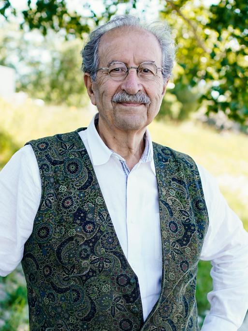 Der Schriftsteller Rafik Schami steht am Rheinufer