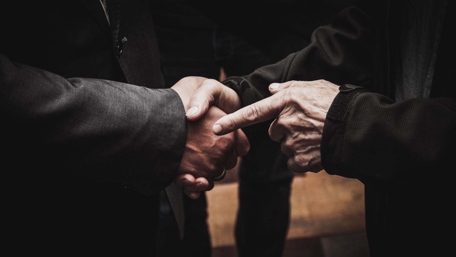 CLOSE-UP OF MAN HOLDING HANDS ON TABLE CLOSE-UP OF MAN HOLDING HANDS ON TABLE