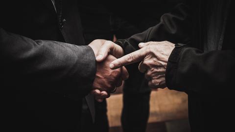 CLOSE-UP OF MAN HOLDING HANDS ON TABLE