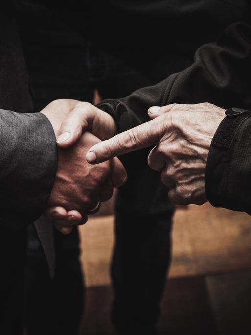 CLOSE-UP OF MAN HOLDING HANDS ON TABLE