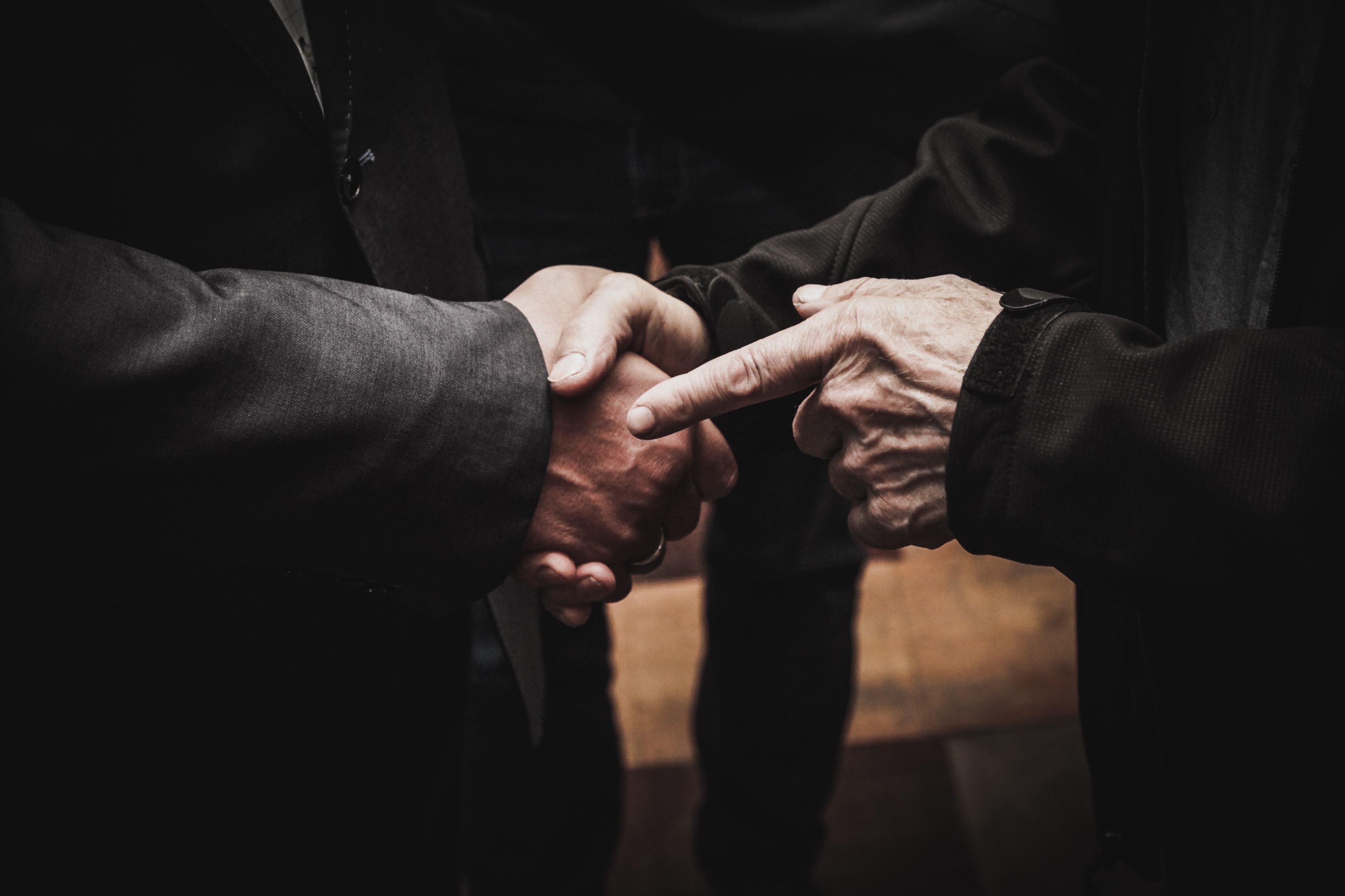 CLOSE-UP OF MAN HOLDING HANDS ON TABLE