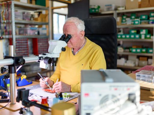 Ein Senior arbeitet in seiner Elektronik-Werkstatt.