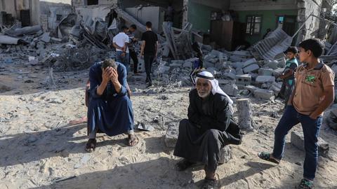 Palästinensische Gebiete, Rafah: Palästinenser sitzen vor einem beschädigten Haus, nachdem israelische Kampfflugzeuge ein Haus bombardiert haben.