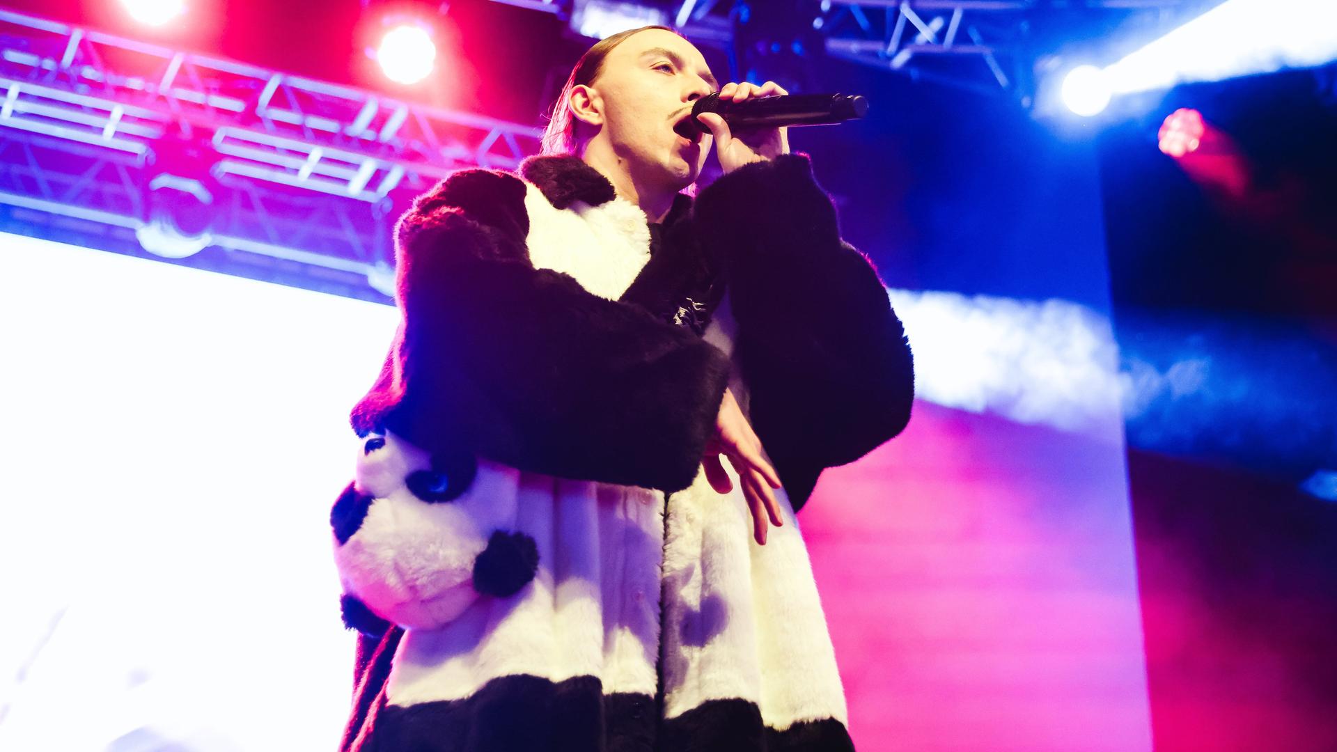 Der estnische Rapper Tommy Cash steht bei einem Konzert in der itlienischen Stadt Mailand im November 2023 auf der Bühne und singt in ein Mikrofon.