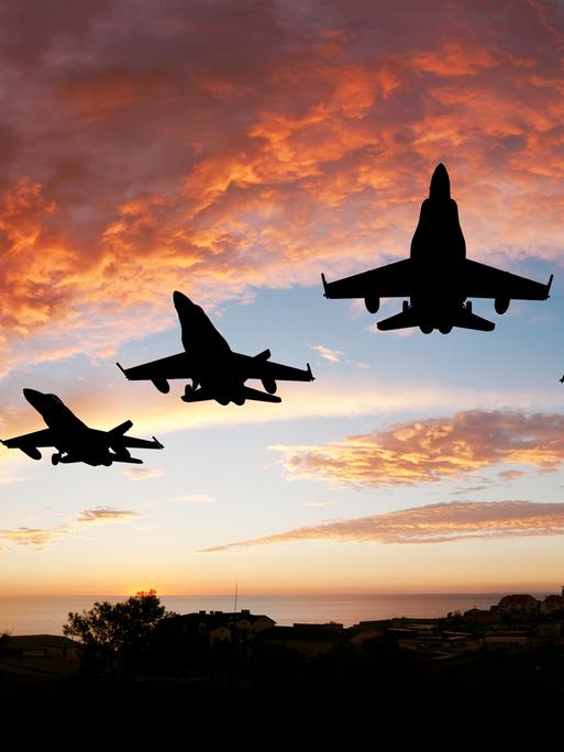 Fünf Kampfflugzeuge vor einem roten Abendhimmel