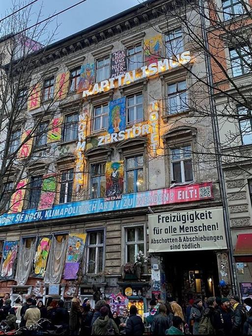 Ein Altbau mit vielen Slogans auf der Fassade. 