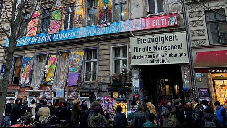 Ein Altbau mit vielen Slogans auf der Fassade. 