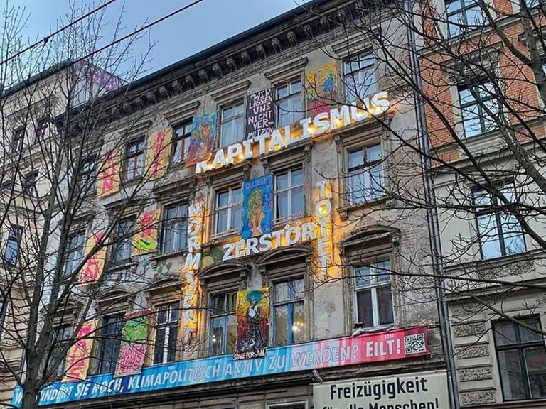 Ein Altbau mit vielen Slogans auf der Fassade. 