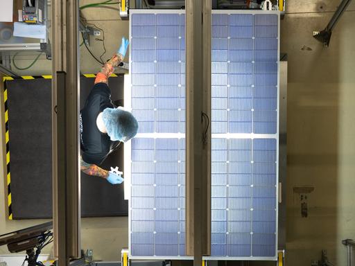 Eine Mitarbeiterin steht bei der Qualitätskontrolle an einer Produktionslinie für Solarmodule im Werk der Meyer Burger Technology AG  in Freiberg.