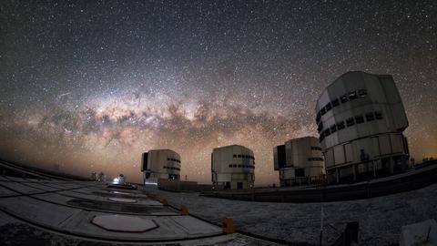 : Im Zentrum der Milchstraße (hier hinter den Teleskopen des Paranal-Observatoriums) befindet sich ein extrem massereiches Schwarzes Loch. 