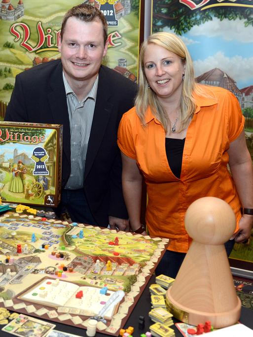 Die Autoren des Spiels "Village", das Ehepaar Inka und Markus Brand, stehen bei der Verleihung des Titels "Spiel des Jahres 2012" in Berlin hinter ihrem Brettspiel. 