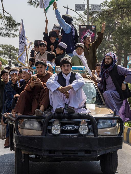 Ein Konvoi von Taliban-Anhängern auf einem Auto bewegt sich durch die Straßen von Kabul.