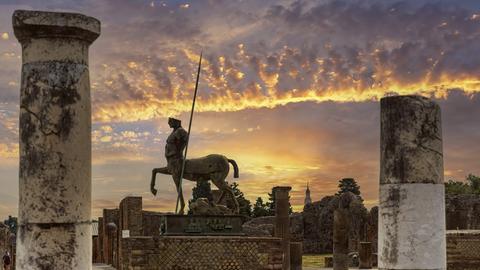 Wir sehen eine Zentauren-Statue vor feuerrotem Himmel. Wir sehen eine Zentauren-Statue vor feuerrotem Himmel.