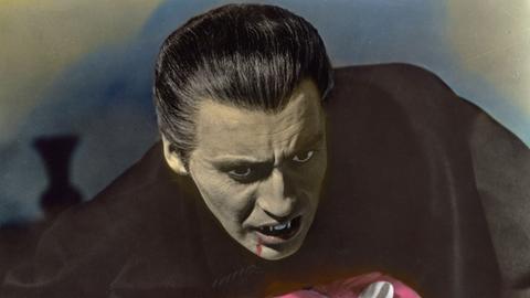 Christopher Lee als Dracula ist gerade dabei, seine Filmpartnerin, die in seinen Armen liegt, einen Biss zu versetzen